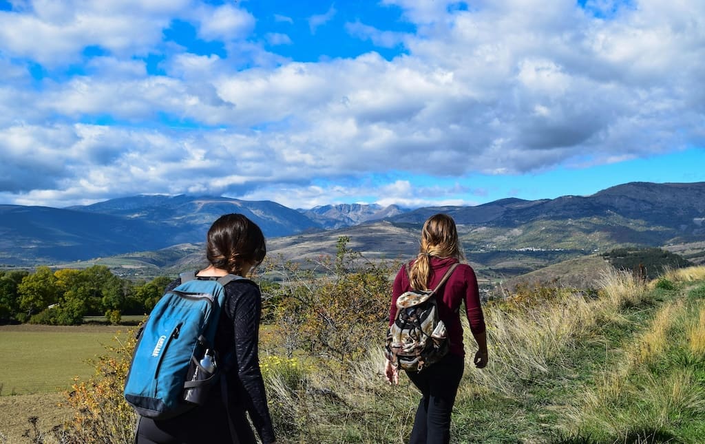 Two young women with backpacks on a hike-a-thon fundraiser