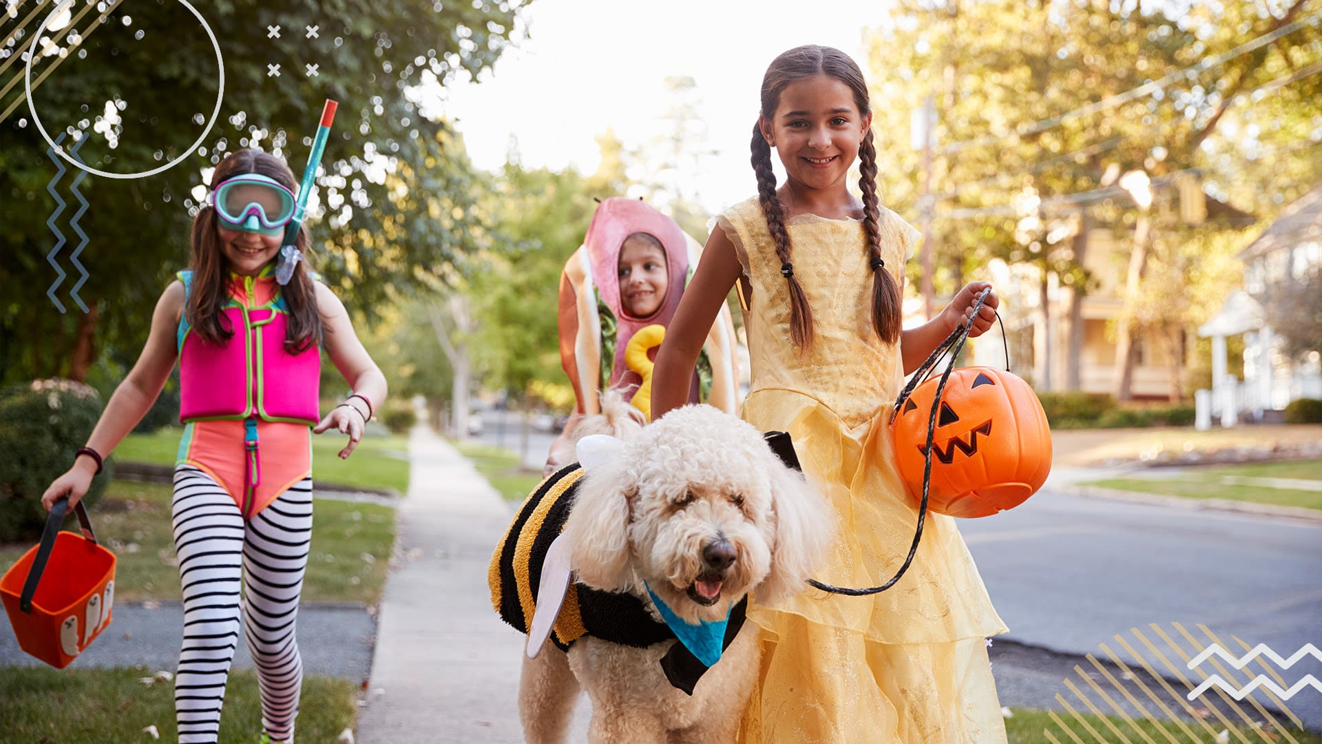 Two young female siblings walking dog in Halloween costumes