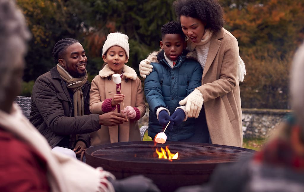 Family roasting marshmallows during a school fundraiser