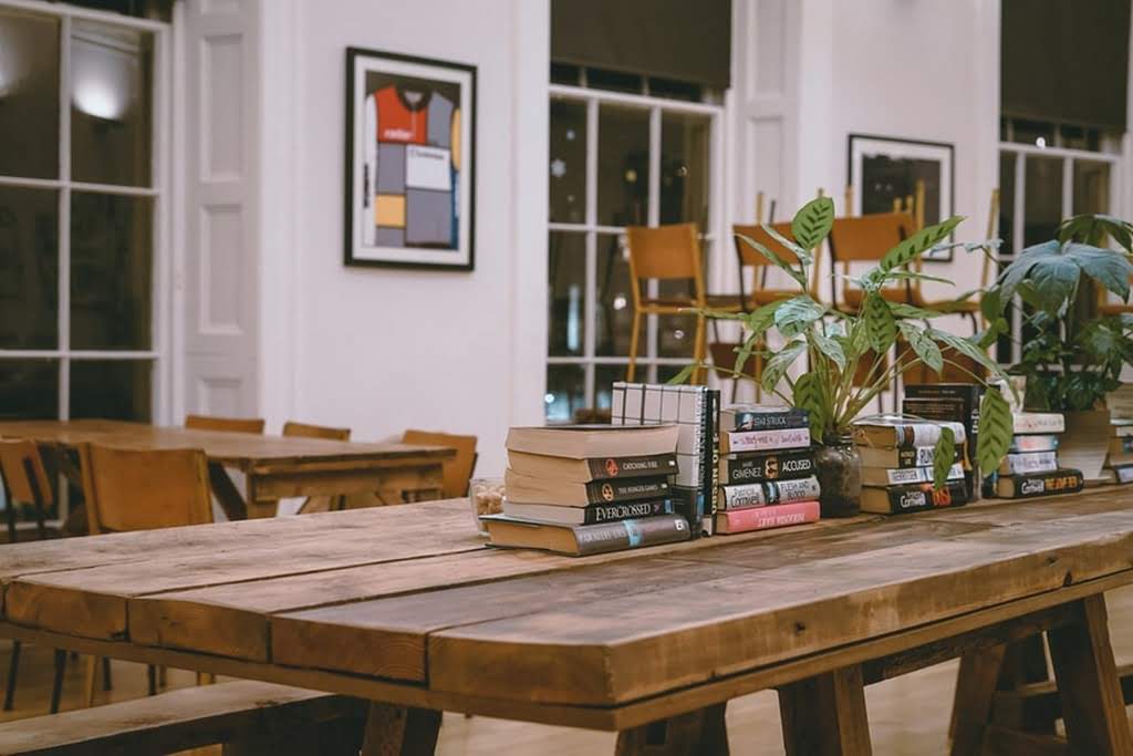 A long wooden table with books as a centerpiece