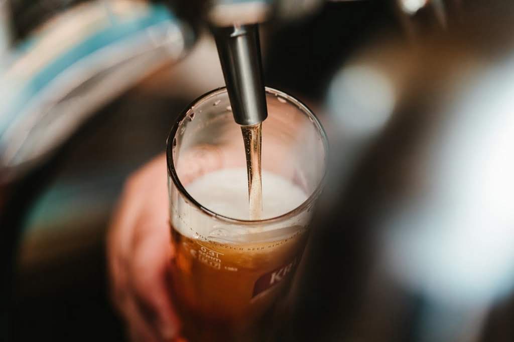 A tap pouring out beer into a glass