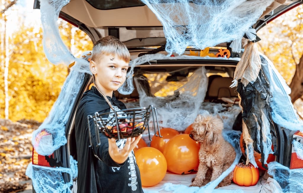 Elementary school kid handing out candy from the trunk of car during a fundraiser