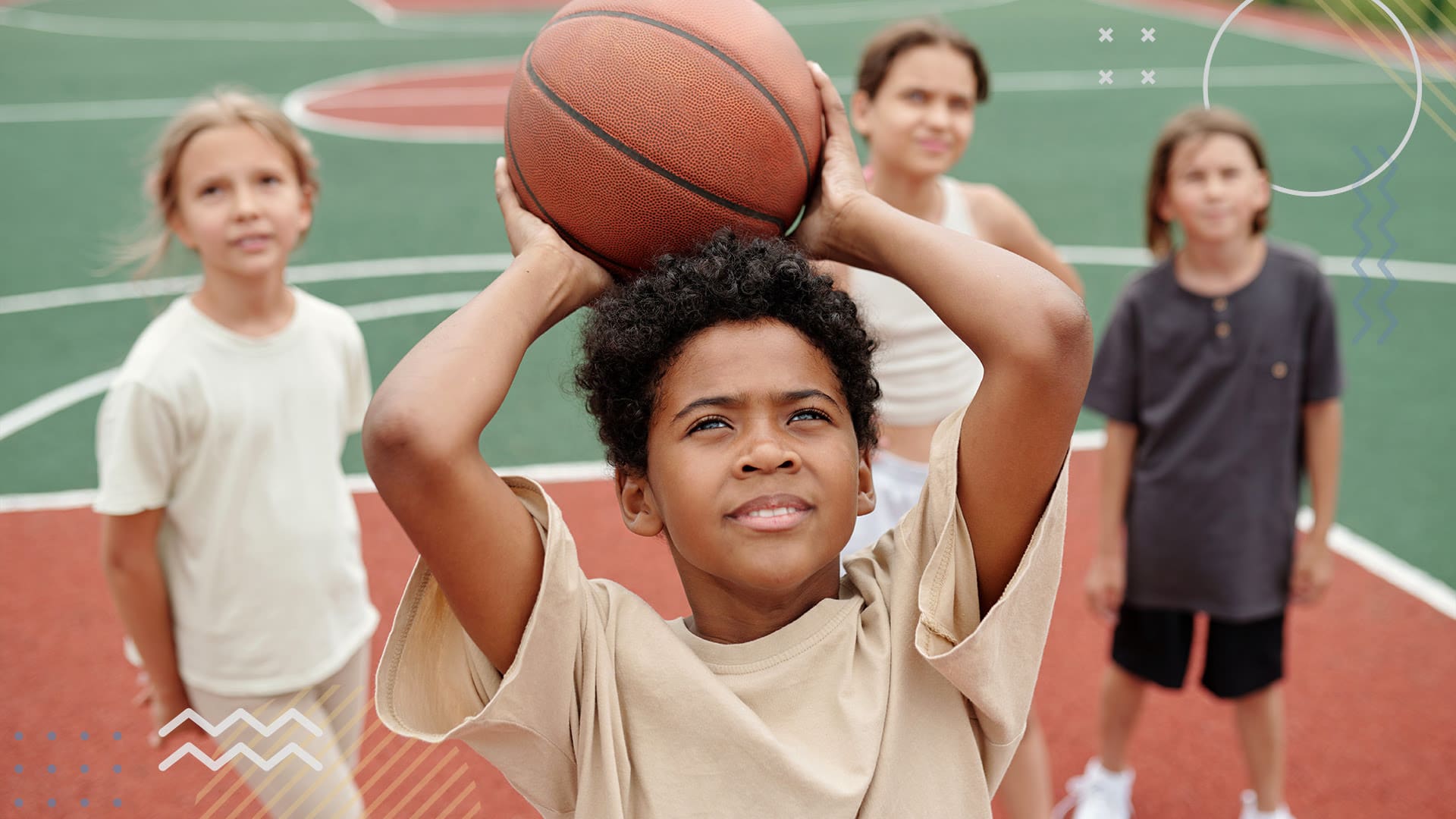 School-aged kids looking up towards a basketball hoop as one of them prepares to take a shot