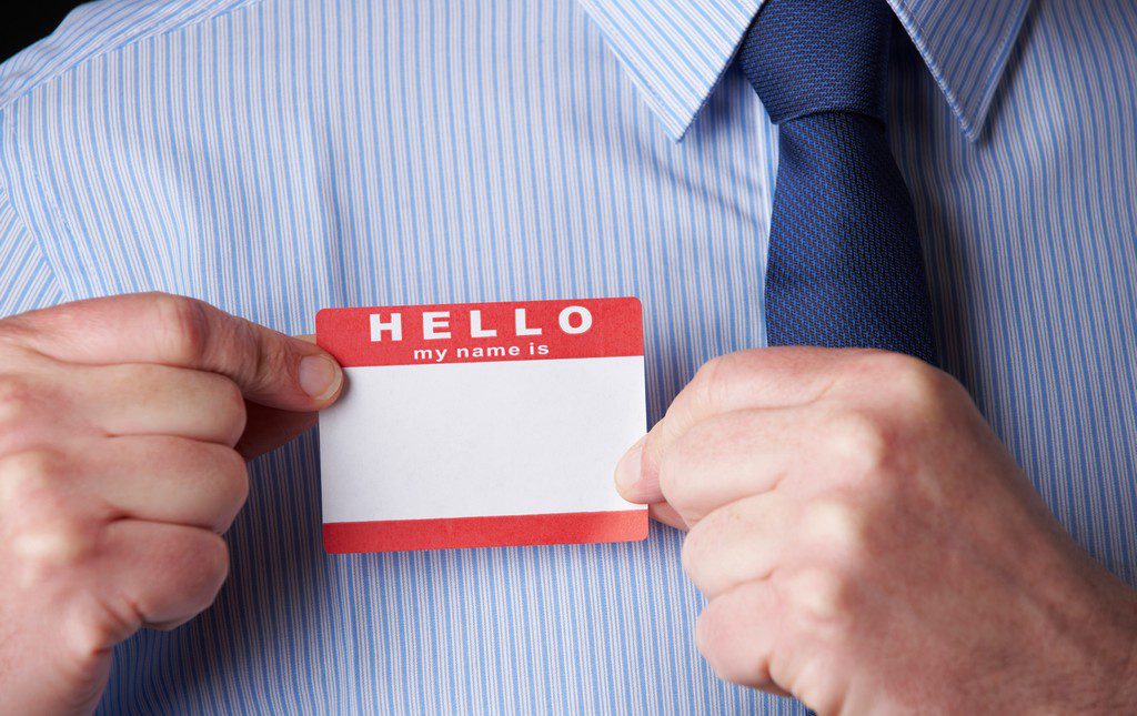 man putting name tag on his chest