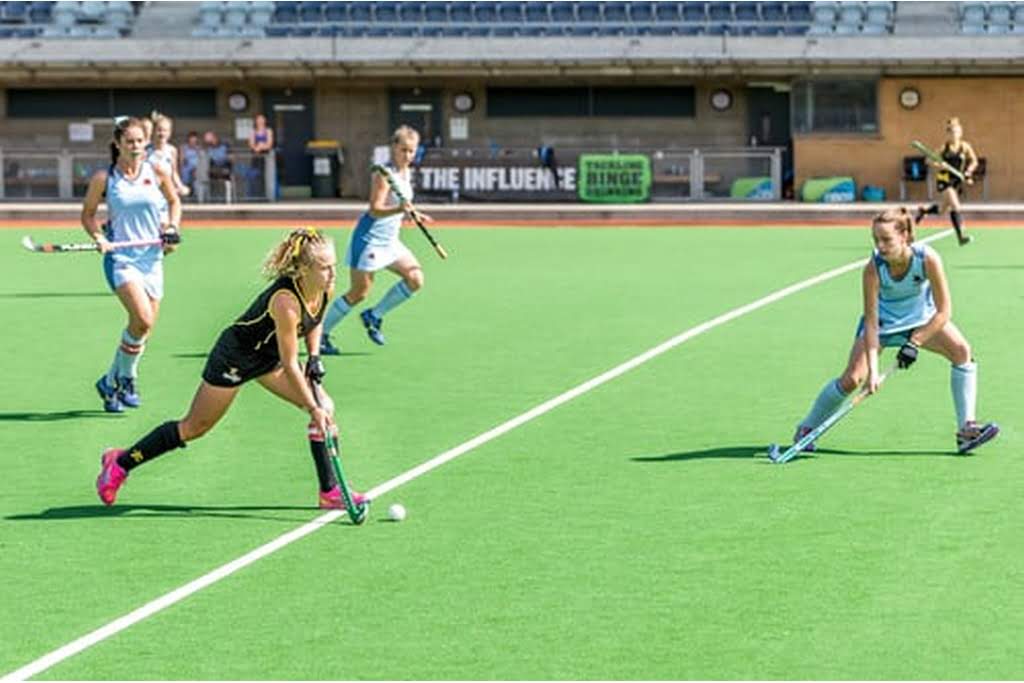 girls playing field hockey