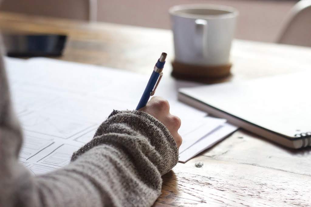 A person writing on a piece of paper