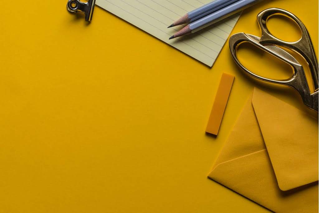 A yellow table with a yellow envelope and scissors