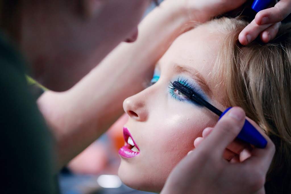 mom putting makeup on kid