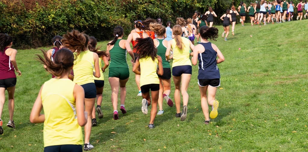 Students participating in fun run on grassy field