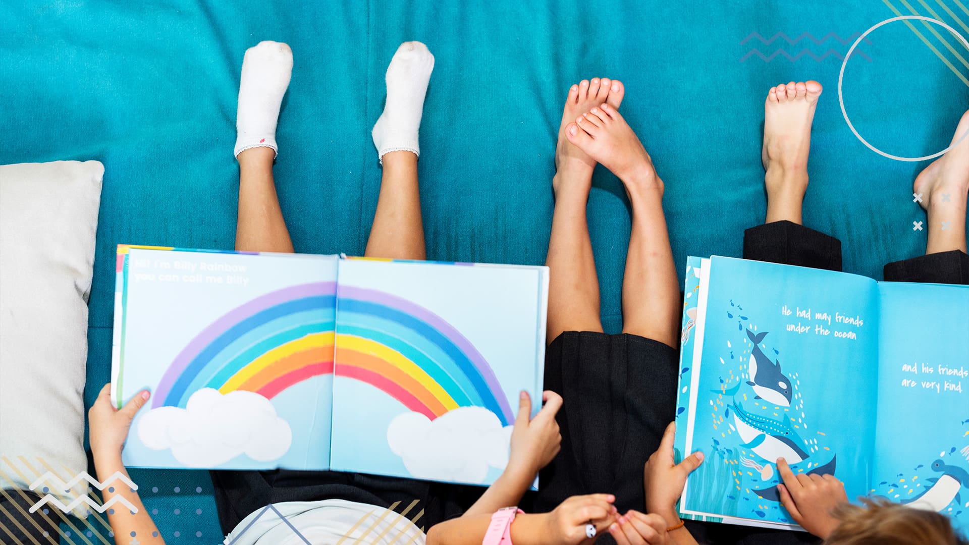 Overhead shot of three children sitting on a blue mat reading storybooks