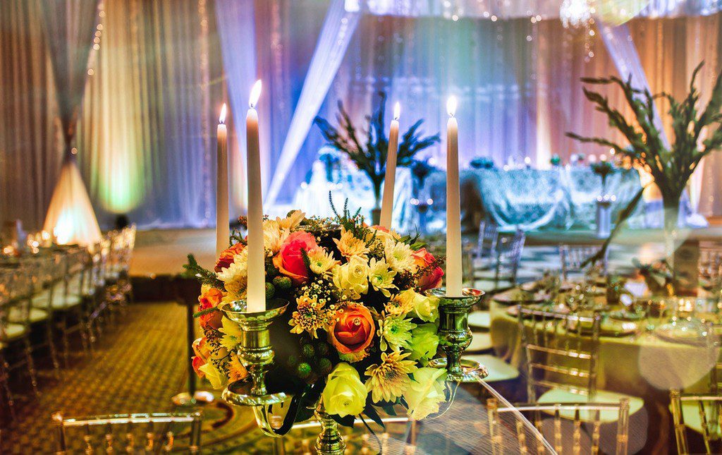 Tables and chairs set up for fundraising dinner with floral arrangements