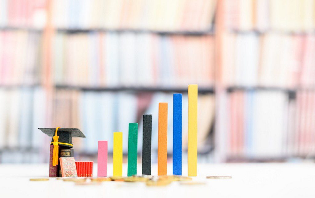 Blocks stacked to make bar graph with mini school hat nearby to symbolize fundraising campaign