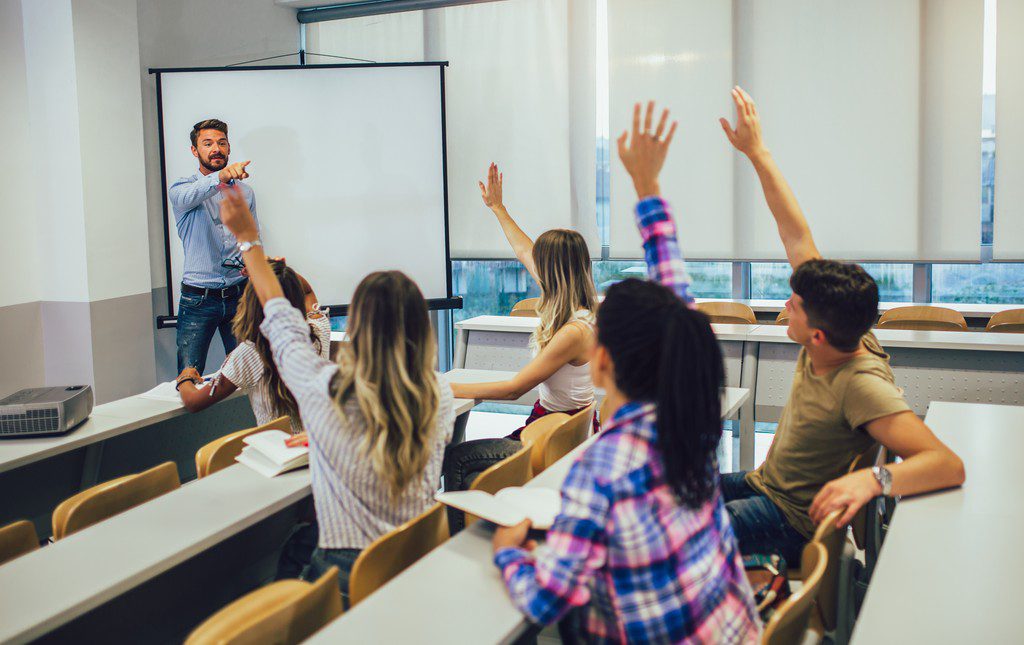 Teacher getting suggestions from students with their hands up