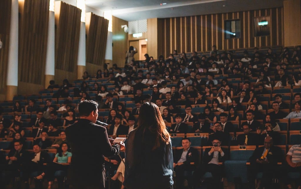 people sitting listening to an award ceremony