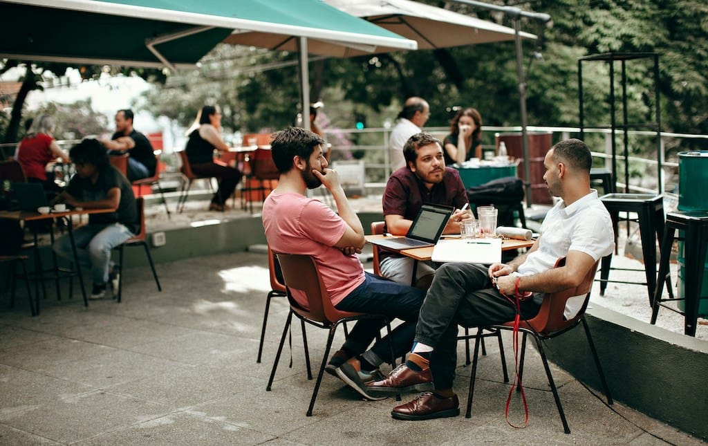 adults talking to each other over lunch on a patio