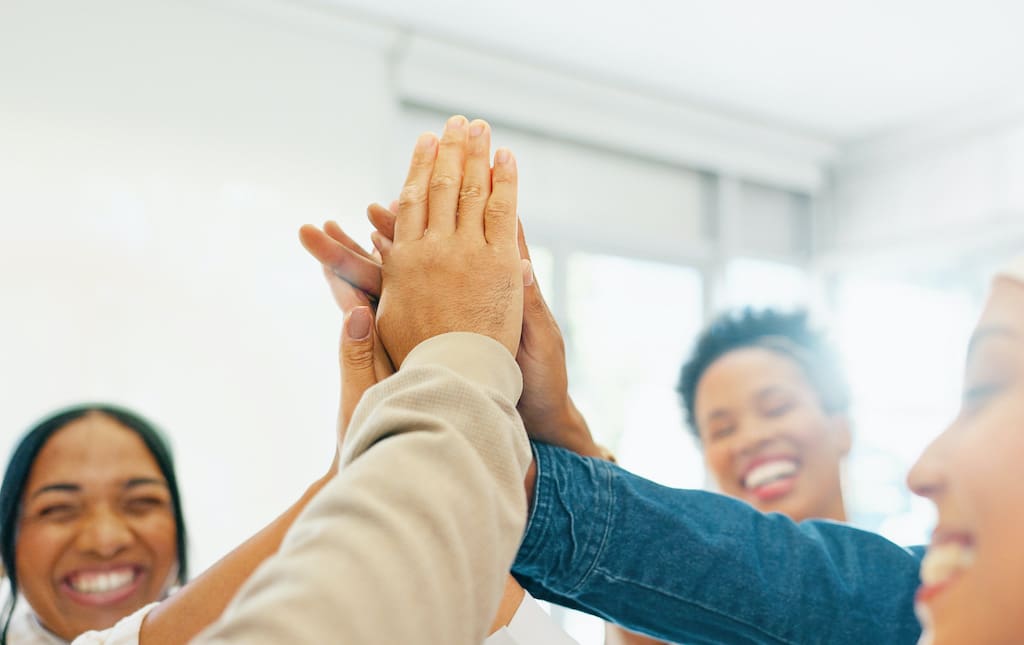 Group of women high-fiving each other