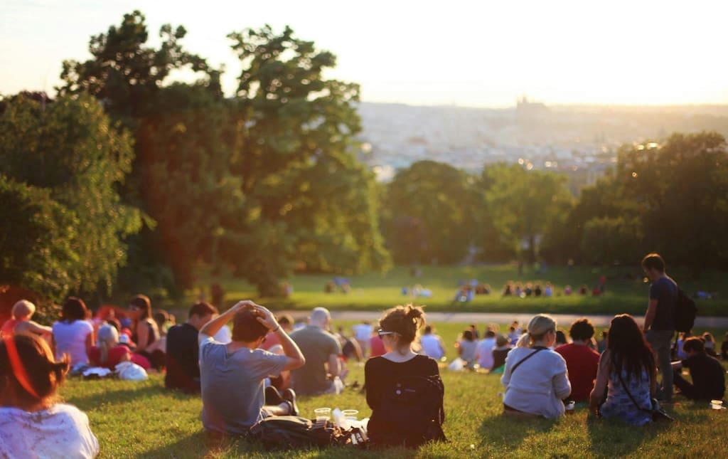 group of people sitting together outside on the grass