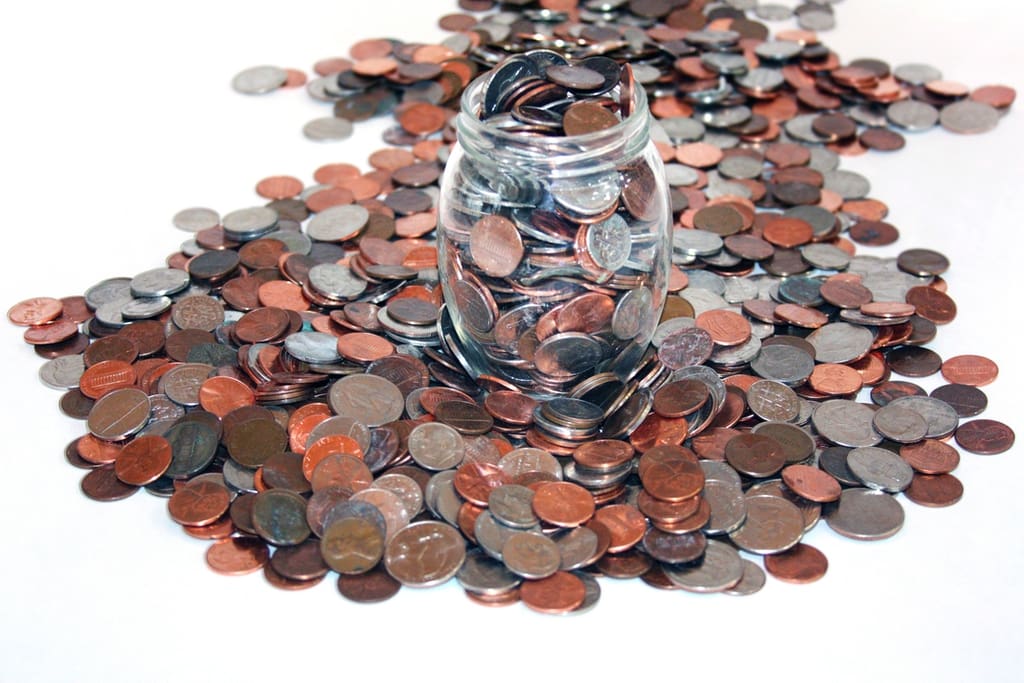 Jar full of US coins for school penny war fundraiser