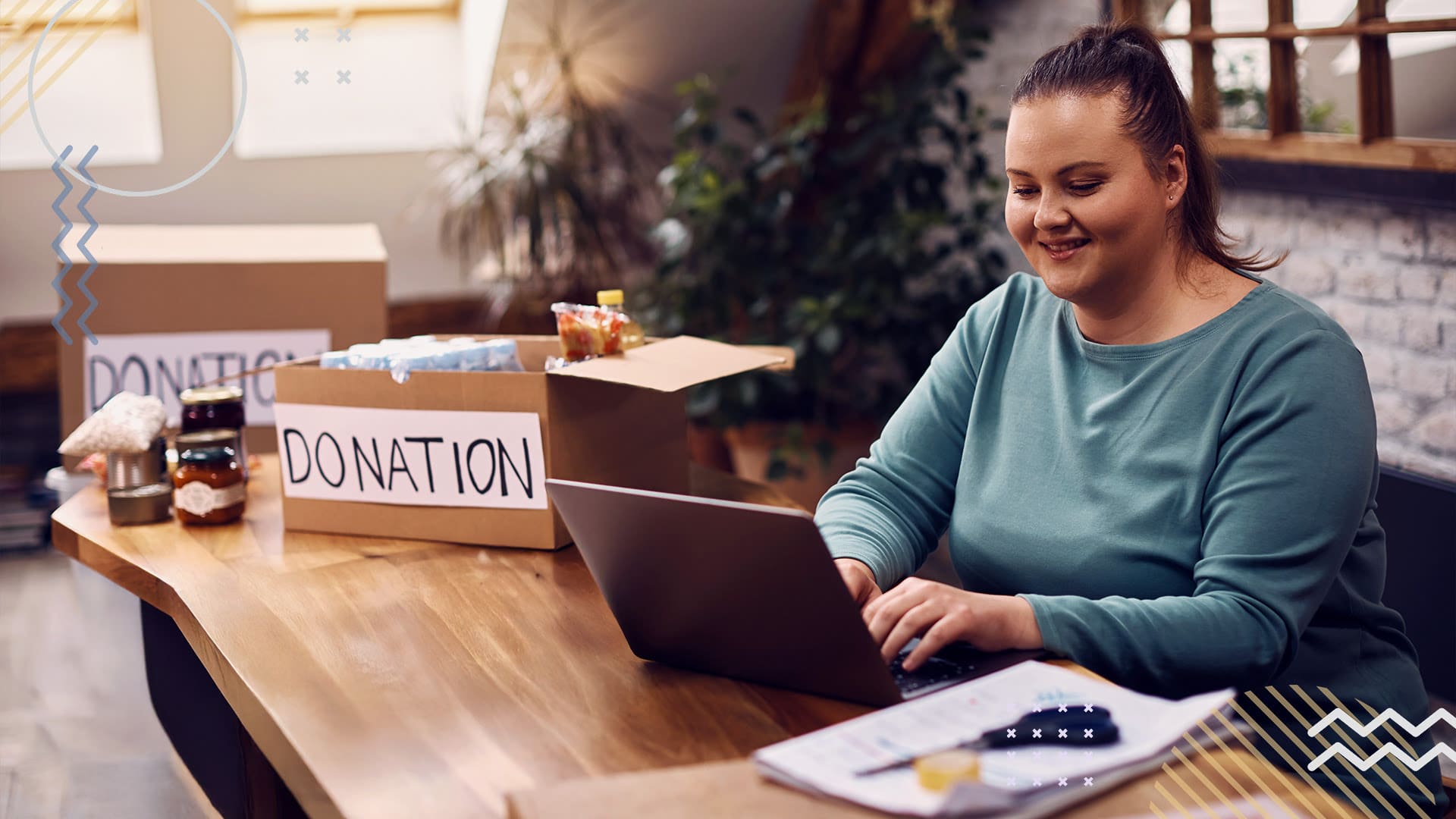 Non profit worker on laptop smiling while looking at incoming donations