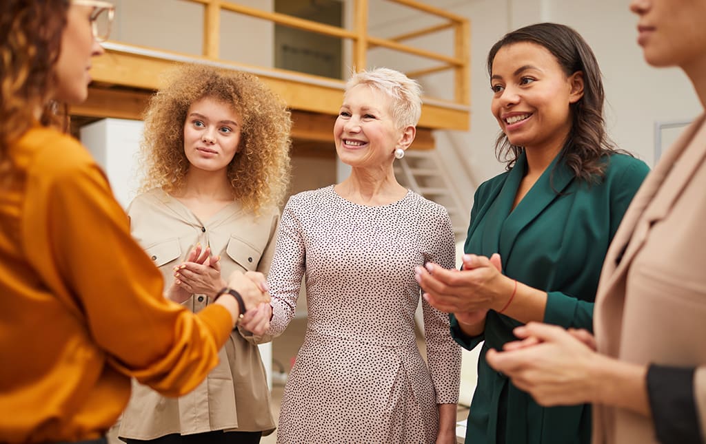 A school fundraising campaign leader shakes hands with a former student