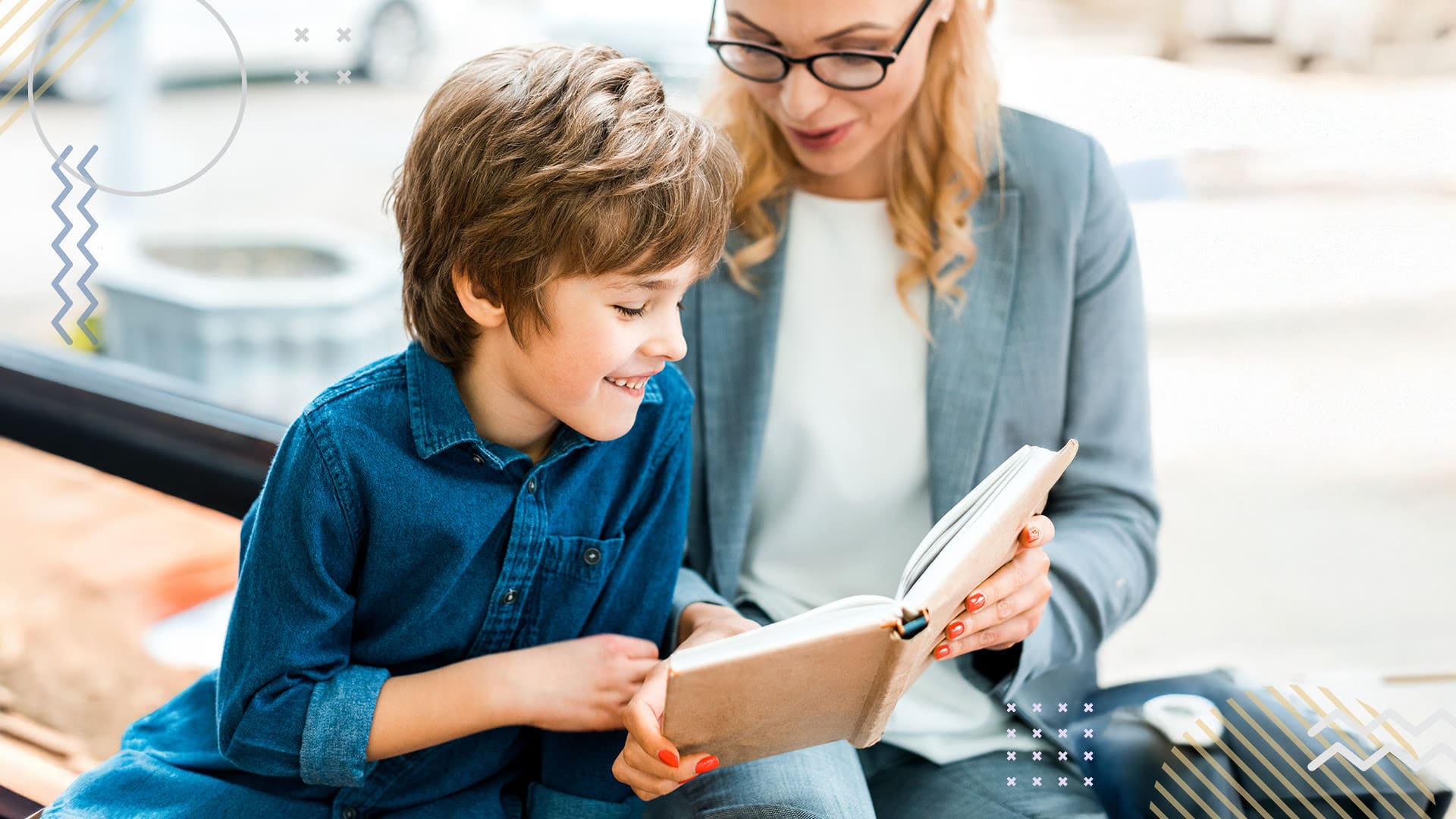 Woman and child seated outside looking at a book of terminology.